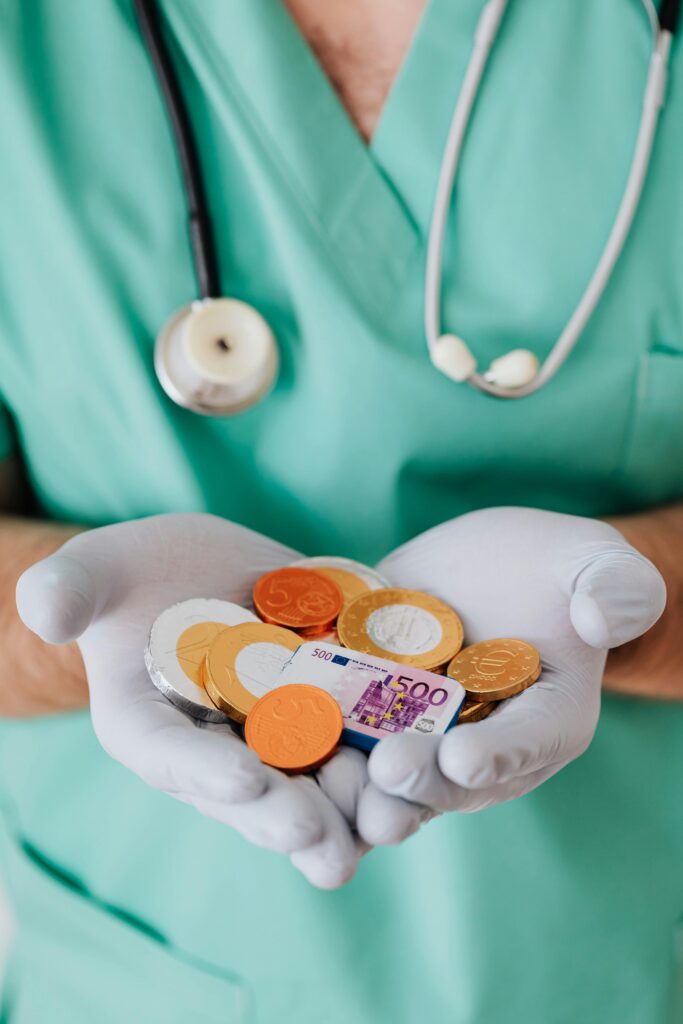 pexels-photo-4021810-4021810 From above crop faceless doctor with stethoscope on shoulders holding in hands chocolate coins